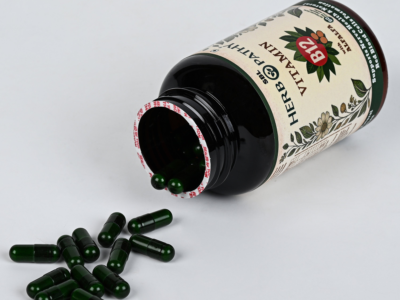 Vitamin B12 with Alfalfa capsules poured out showing green vegetarian capsules